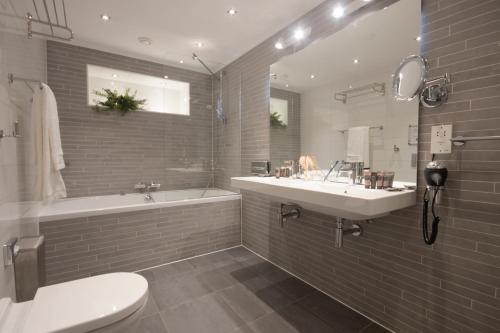 阿姆斯特丹Grand Canal Boutique Hotel的一间带水槽、浴缸和卫生间的浴室