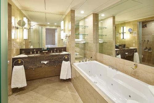 杜塞尔多夫Clayton Hotel Düsseldorf City Centre的带浴缸和大镜子的大浴室