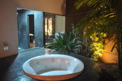 福塔莱萨派拉斯汽车旅馆（仅接待成人）的浴室的浴缸位于柜台上