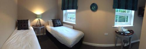 萨顿布里奇安卡尔宾馆的一间卧室设有两张床和两个窗户。