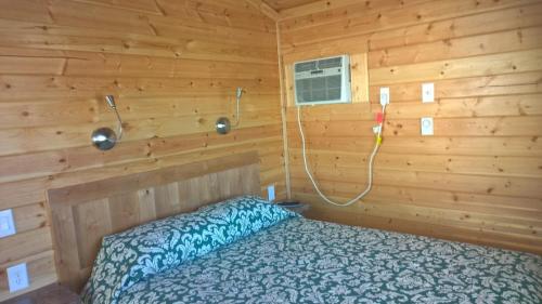 NicolausLake Minden Camping Resort Cottage 1的小木屋内一间卧室,配有一张床