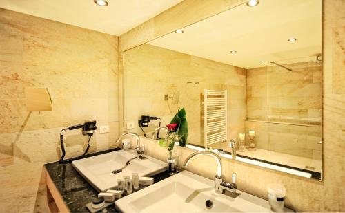 伊施格尔Salnerhof Superior Lifestyle Resort的一间带两个盥洗盆和大镜子的浴室