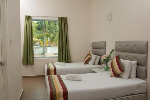 波德申阿加海滩度假酒店的带窗户的客房内的两张床