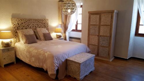 Santa-Lucia-di-TallanoCasa Corsa的一间卧室配有一张床、两盏灯和吊灯。