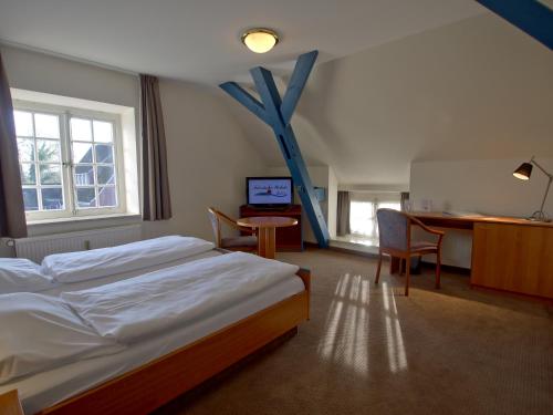 博克霍尔恩福瑞斯彻伍哈德酒店的配有一张床、一张桌子和一张桌子的酒店客房
