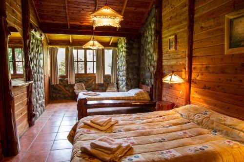 埃博森Morada del Sol - Experiencia de Montaña的小木屋内一间卧室,配有两张床