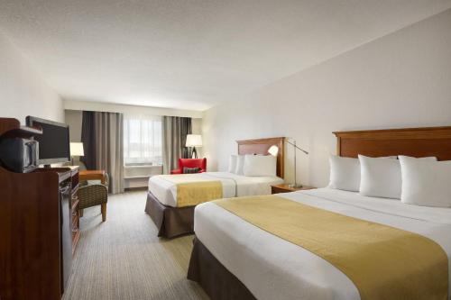 悉尼悉尼乡村酒店及套房的酒店客房设有两张床和电视。