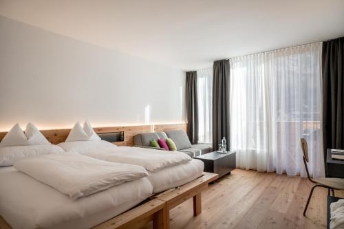 索尔登索尔登贝格生活酒店的卧室配有一张白色的大床和一张沙发。