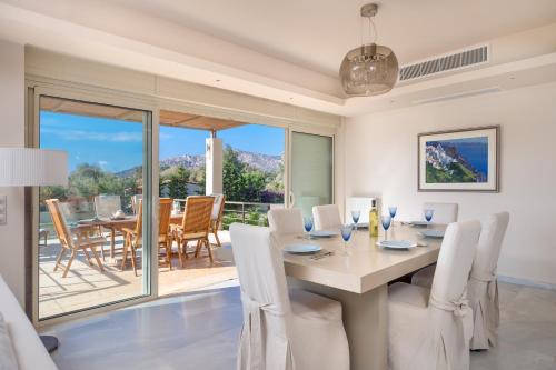 苏尼翁Legrena Beach Villa的一间带桌椅的用餐室和一个阳台