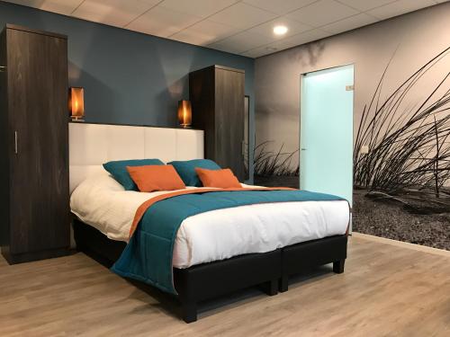 斯鲁伊斯Rivers Hotel的一间卧室配有蓝色和橙色枕头的床