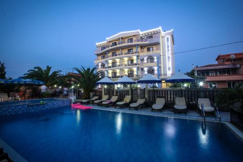 乌尔齐尼Spa Hotel Montefila的一个带椅子的游泳池和一个背景建筑