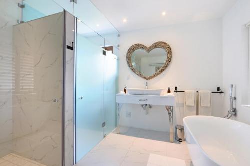 戈登湾杏花园旅馆的带浴缸、水槽和镜子的浴室