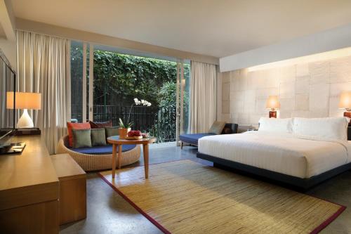 塞米亚克Cross Paasha Bali Seminyak的一间卧室设有一张床和一间客厅。