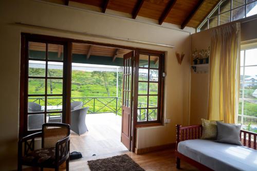 努沃勒埃利耶茶园乡村民宿的一间卧室设有一张床和一个滑动玻璃门