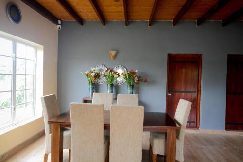 努沃勒埃利耶茶园乡村民宿的一间带桌椅和鲜花的用餐室