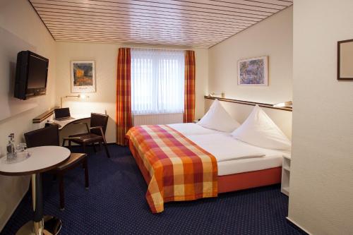 沃尔夫斯堡戈雅中心酒店的酒店客房配有一张床铺和一张桌子。