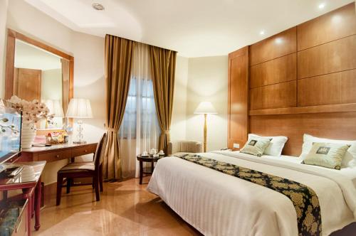 棉兰樱花大酒店的配有一张床和一张书桌的酒店客房