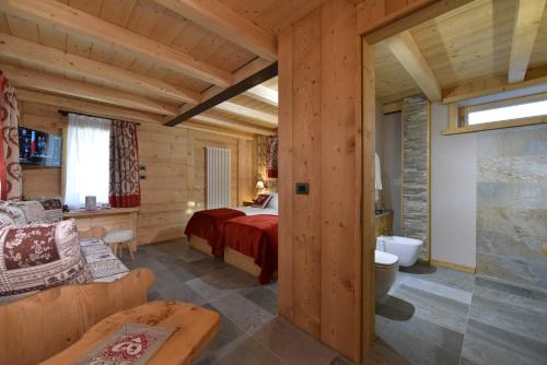 布勒伊-切尔维尼亚Il Cuore Del Cervino的小木屋内一间卧室,配有一张床和一张沙发