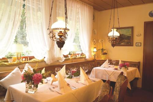 RiefensbeekLandhaus Meyer的一间用餐室,配有2张带白色桌布的桌子
