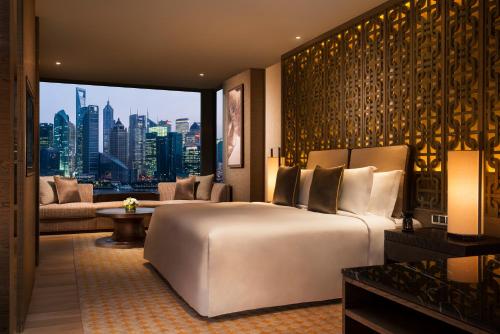 上海上海外滩悦榕庄的一间带一张大床的卧室,享有城市美景