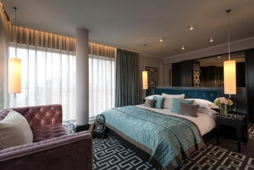贝尔法斯特首选贝尔法斯特费兹威廉酒店的一间卧室配有一张大床和一张沙发