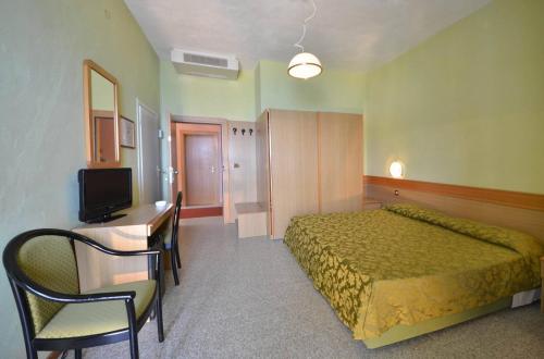 卡波利韦里斯特拉马里斯酒店的一间卧室配有一张床、一张书桌和一台电视