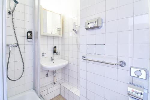 柏林Hotel Europa City的白色的浴室设有水槽和淋浴。
