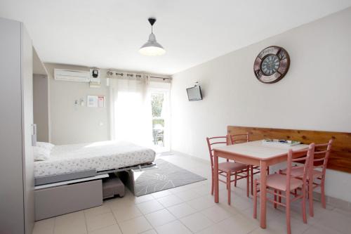 蒙托鲁Le Champ d'Eysson Aparthotel的一间卧室配有桌椅和一张床