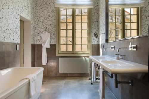 于泽斯于泽斯驿站城堡旅馆的浴室配有两个盥洗盆和浴缸。