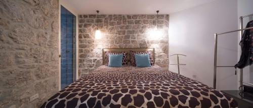 泽斯特拉格Villa Jatica的一间卧室设有一张带石墙的大床