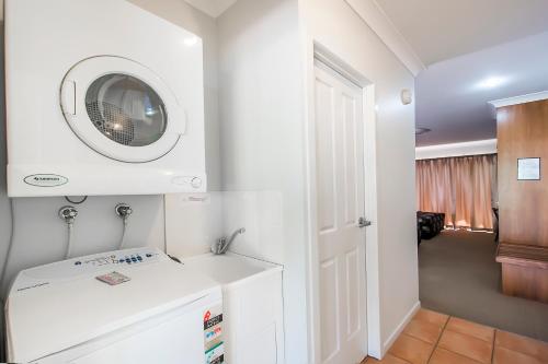 麦凯新乐花园汽车旅馆的白色的浴室设有水槽和微波炉。