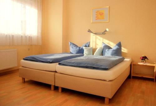 吕德斯海姆科隆路德施姆酒店的一间卧室配有一张带蓝色枕头的床。