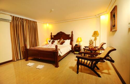 仰光联合广场酒店的卧室配有一张床和一张桌子及椅子