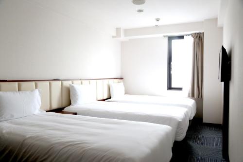 成田成田爱森酒店的配有窗户的酒店客房内的两张床