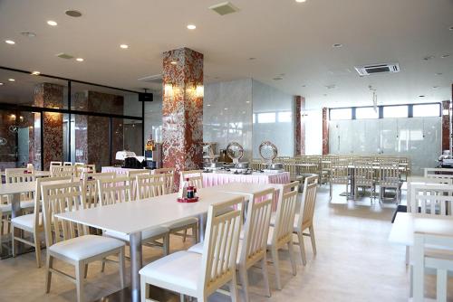 成田成田爱森酒店的一间设有白色桌椅的用餐室