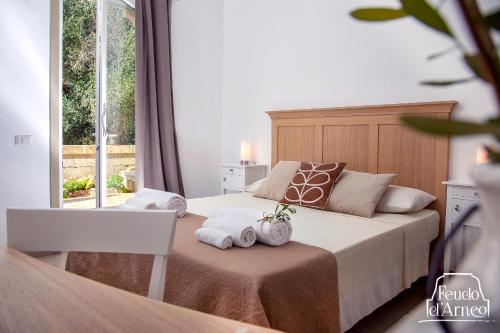 托雷拉皮罗Feudo d'Arneo的一间卧室配有带毛巾的床