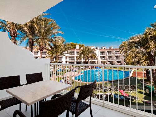 帕尔马诺瓦卡斯萨博尼尔斯海滩酒店的一个带桌椅的阳台和一个游泳池