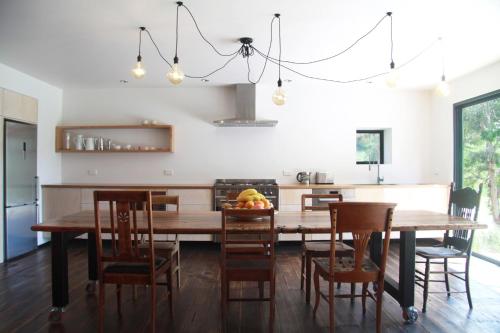 休恩维尔大棚度假屋的厨房以及带木桌和椅子的用餐室。