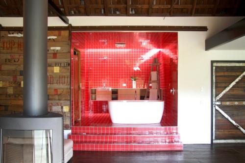 休恩维尔大棚度假屋的一间红色的浴室,在房间内配有白色浴缸