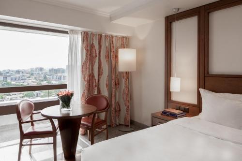 拉各斯Eko Hotel Main Building的酒店客房设有床、桌子和窗户。
