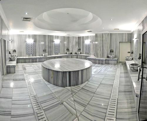 AksehirOzpark Hotel的一间设有美发沙龙的房间,设有圆桌