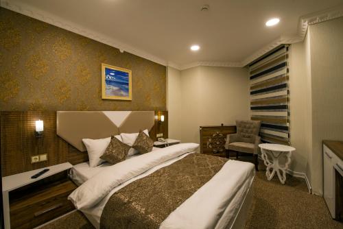 卡尔斯Kars-i Si̇ri̇n Otel的酒店客房带一张大床和一把椅子