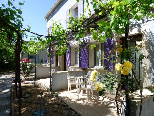 阿维尼翁Appart'Hotel Festival Sud Aqua - Avignon TGV的一座带紫色窗帘和鲜花的庭院