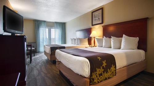 杜威海滩杜威金叶酒店的酒店客房设有两张床和一台平面电视。
