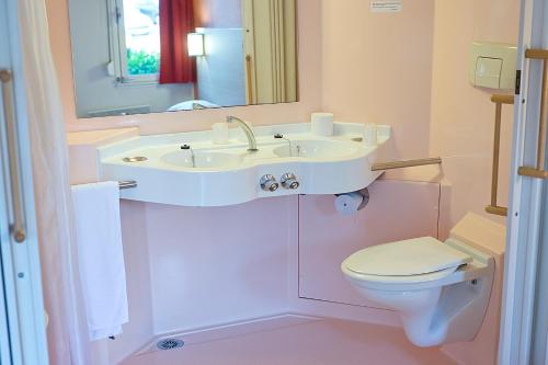 奥比埃普瑞米尔克雷蒙费兰德奥比耶尔经典酒店的浴室配有白色水槽和卫生间。
