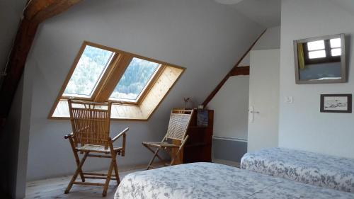 Saint-Pierre-dʼEntremont拉穗德辉杜潘松住宿加早餐旅馆的一间卧室配有两把椅子、一张床和窗户