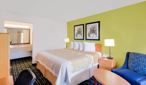 伊斯顿伊斯顿戴斯酒店的酒店客房,配有一张床和一张蓝色椅子