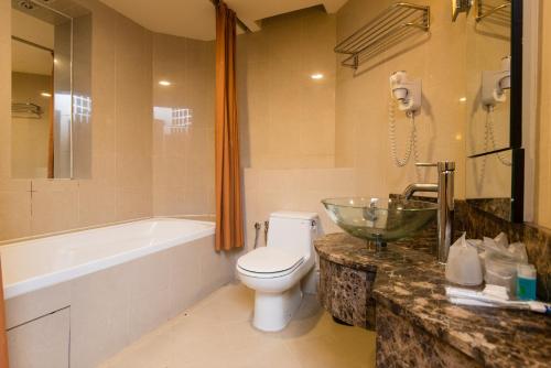 梳邦再也金字塔新城度假村套房公寓的浴室配有卫生间、浴缸和水槽。