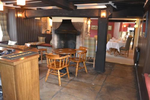 WassThe Stapylton Arms的一间带桌子和壁炉的用餐室