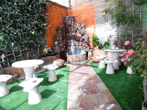普诺普诺特拉酒店的花园配有白色的桌椅和喷泉